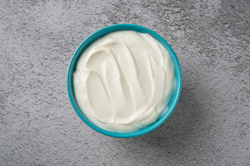 Top view of yogurt in bowl on grey stone table. Healthy eating concept