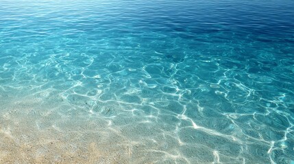 Overhead view of vibrant blue tropical ocean water with sunlight rippling through, faint sand visible, and spacious copy area on the left