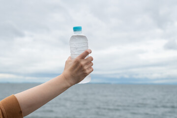 水のペットボトルを持っている人	