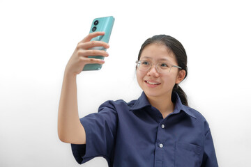 Young Asian Woman Wearing a Navy Blue Shirt Smiling While Taking Her Holding Up Smartphone for a Self-Portrait