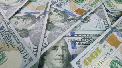 A variety of United States Hundred Dollar Bills displayed on a flat surface area