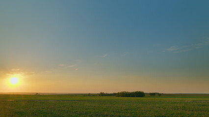 A Serene and Beautiful Sunset Over the Expansive Lush Green Fields with Vibrant Colors