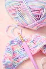 パステルカラーの毛糸でかぎ針編みをする編み物のイメージ