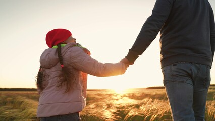 girl holds father hand comma. Happy family comma. Evening walk sunset in Comma Park. Child girl...