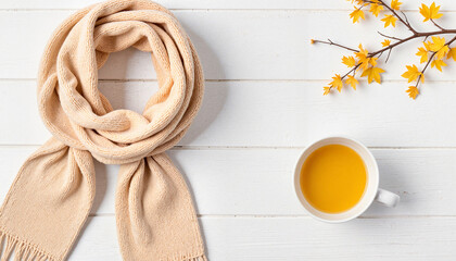Cozy scarf and cup of tea on wooden table