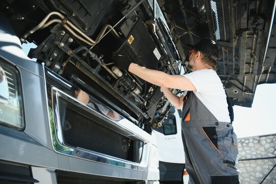 A senior worker checks wheel. Truck malfunction. Service work