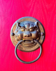 Dragon head door handle on the red door in a buddhist temple in the Sanya Nanshan Cultural Center