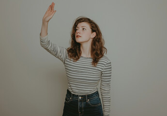 Full-Body Portrait of a Young Woman in Jeans and Striped Top – Artistic Pose with Open Palm and Raised Hand, White Background, Studio Shot, High-Resolution Fashion and Lifestyle Photography