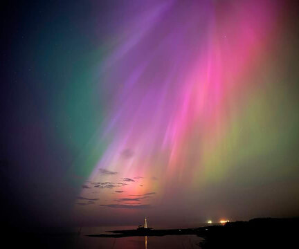 The aurora borealis, also known as the northern lights, glow on the horizon at St. Mary's Lighthouse in Whitley Bay on the North East coast, England, Friday, May 10, 2024. (Owen Humphreys/PA via AP)