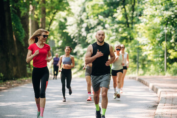 Joggers are on the road. Group of runners are together outdoors