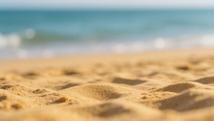 Golden sand texture with soft focus, warm tones, and blurred seascape, evoking serene summer tranquility.