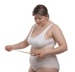Weight loss. Plus size woman measuring waist with tape on white background