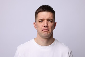 Portrait of stressed man on light background