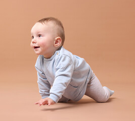 Cute little baby crawling on beige background