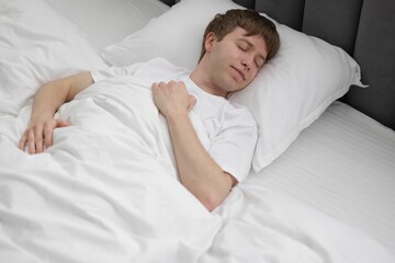 Young man sleeping in bed at home