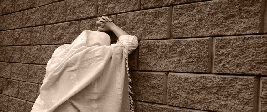 Young woman pray at the wall
