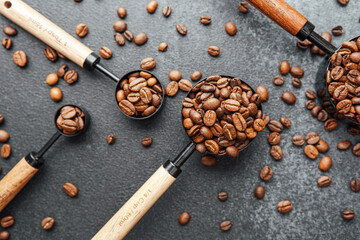Three measuring spoons filled with coffee beans flat lay