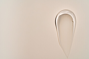 Pure transparent cosmetic gel smear on beige background, skin care glycerin texture. top view. space for text