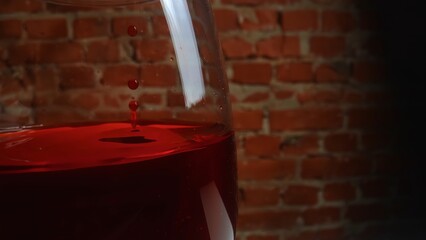 Close-up View of Red Wine in Glass Against Brick Wall