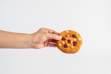 Vanilla cookies topped with nuts and strawberries and hand on a white background
