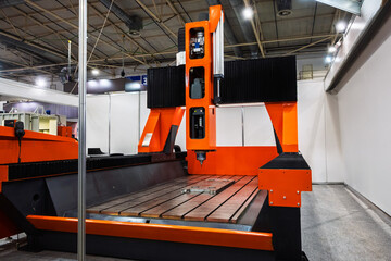 Large orange and black CNC machine in an industrial setting. Modern manufacturing technology for...