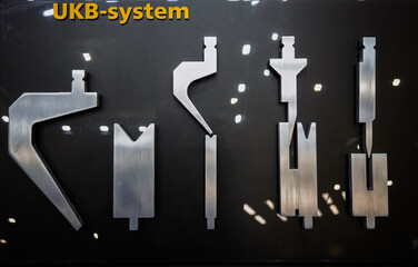 Display of precision metal tools and components for the UKB-system, showcased on a black board at...