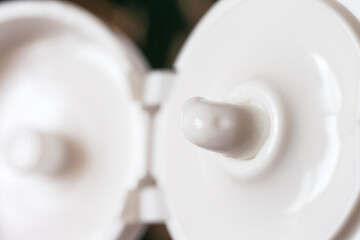 White cosmetic moisturizing anti-aging natural cream for facial skin care squeezed out of the plastic tube. Blurred silhouettes of tube. Summer skin care concept. Top view, close-up, macro