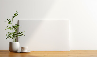 A clean and minimalist composition featuring a potted plant beside a blank canvas on a wooden tabletop, ideal for inspiring creativity and tranquility.