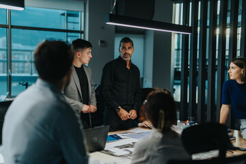 A multiracial group of business people collaborating in an office. They are discussing ideas and strategies, showcasing teamwork and innovative thinking. The setting reflects a modern work environment
