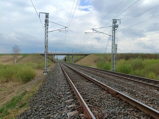Two way railway tracks and bridge. Two railroad tracks. Concrete bridge. Cloudy day. Countryside....