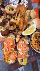 Seafood as a italian dish. Grilled salmon and shrimps with vegetables, lemon and bread. Food ready to eat on the table in Italy. Close up.