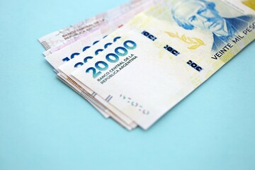 Argentine pesos money bills in big amount lies on teal color table close up