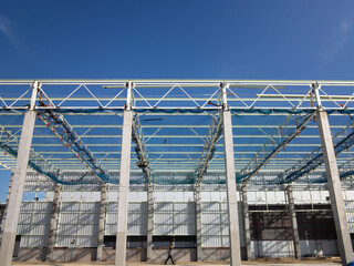 Roof under construction in construction site . To election or assembly frame truss, steel structure for cover factory warehouse building. Include scaffolding and safety net to prevent worker falling.