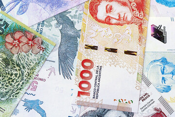 Argentine pesos money bills in big amount lies on white table close up