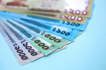 Bangladeshi taka money bills in big amount lies on teal color table close up