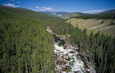 Altai river Chulyshman with coastal rocks and siberian larch taiga forest.