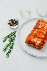 Marinated pork ribs on white plate with rosemary and spices