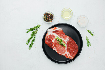 Pork steak with rosemary on black plate with spices