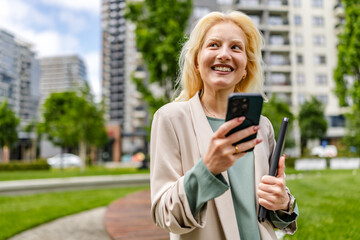 Young woman with albinism enjoying a sunny day in the park while using her smartphone and tablet