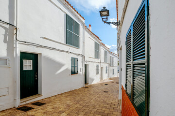Quaint Whitewashed Street With Green Shutters In A Traditional Menorcan Village. Balearic Islands Architecture, Sunny Day, Spanish Island Charm