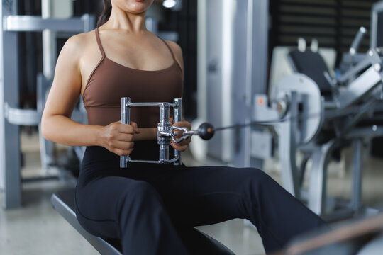 Woman doing seated cable rows exercise in gym for back workout