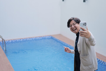 A man is taking a picture of himself in a pool