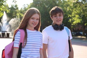 Obraz premium Teenage girl and boy walking together in park