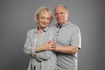 Portrait of lovely senior couple on grey background