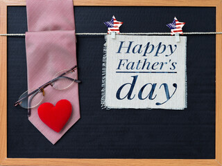 Happy Father's day card with necktie and eyeglasses with red heart on black background, father's...