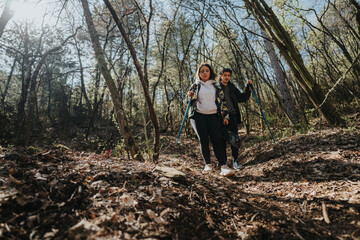 A couple walking with hiking sticks on a scenic forest path, enjoying nature and exercise in a peaceful outdoor setting under natural sunlight.