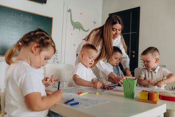 Helping the kids, education. Children in kindergarten with their teacher
