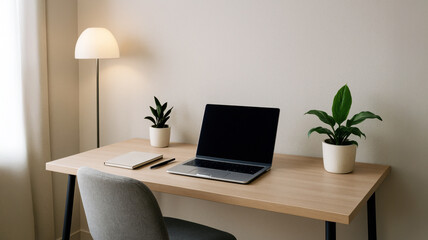 Fototapeta premium Minimalistic home office setup with closed laptop, two green potted plants, notebook and lamp on wooden desk in neutral-toned room. Calm and cozy workspace.