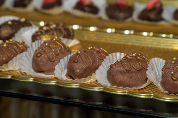 Luxurious handmade decorative chocolates in a display case of assorted pralines with selective...
