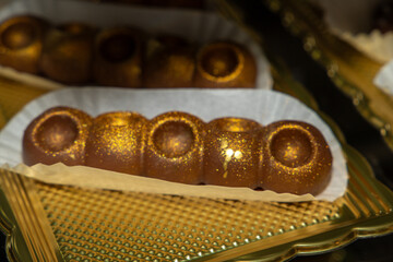 Luxurious handmade decorative chocolates in a display case of assorted pralines with selective accent.